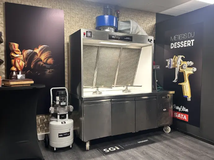 Vue intérieure du showroom SGI Pastry avec équipements professionnels : hottes, compresseurs et pistolets de pulvérisation