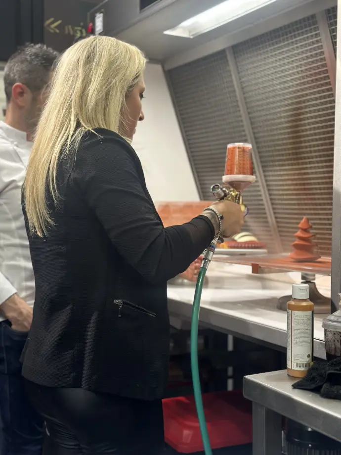 Démonstration de pulvérisation avec Vanessa, responsable SGI Pastry, au SIRHA 2025 Vanessa de SGI Pastry pulvérisant des pâtisseries avec un SATAjet1000 B RP Pastry au SIRHA 2025