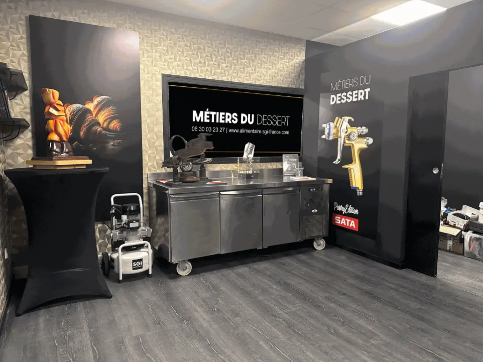 Showroom SGI Pastry : présentation des équipements en situation réelle pour démonstration et test produit Vue intérieure du showroom SGI Pastry avec équipements professionnels : hottes, compresseurs et pistolets de pulvérisation