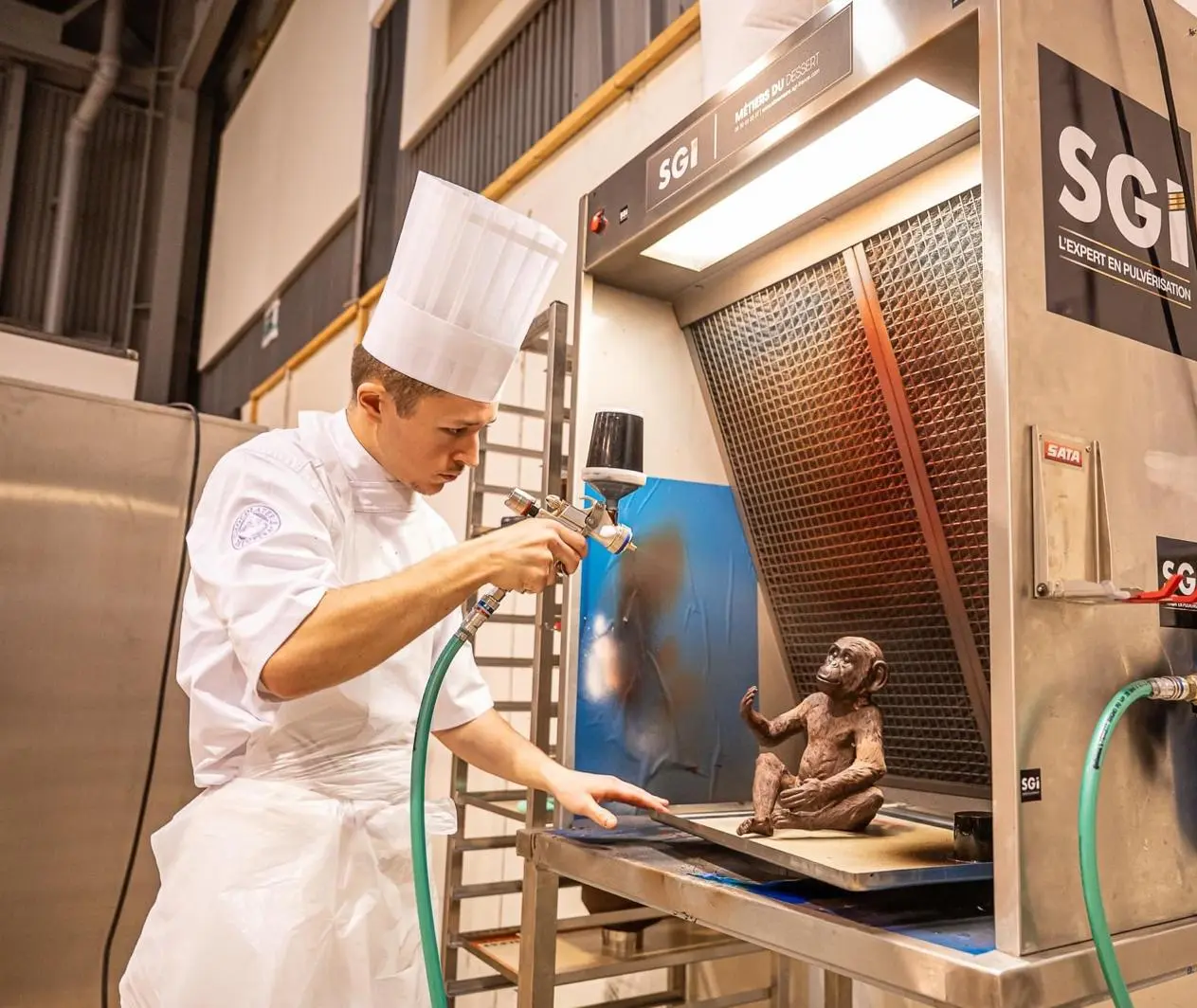 Pâtissier utilisant la hotte compacte SGI Pastry pour pulvérisation 